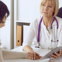 Kind woman doctor discusses medical information with her female patient.