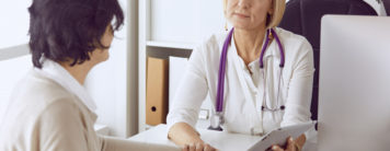 Kind woman doctor discusses medical information with her female patient.