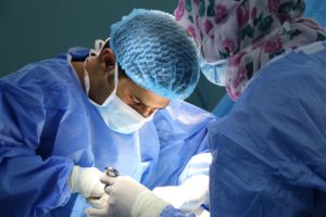 a surgeon and a nurse perform an operation