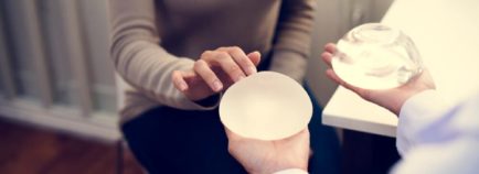 Woman choosing between silicone and saline breast implants.